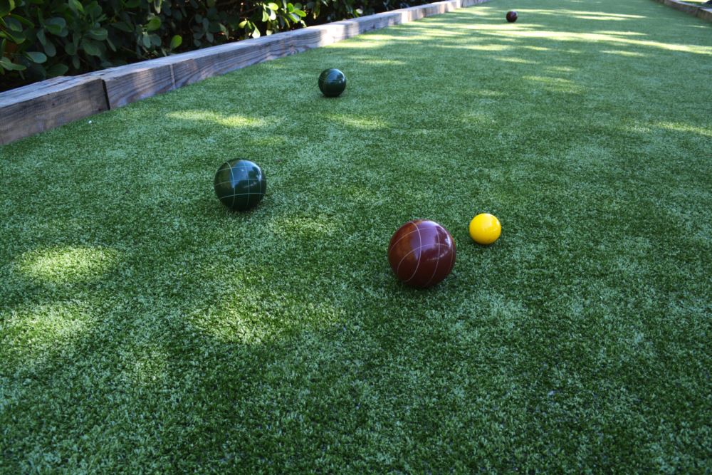 Bocce balls laid out on a lush, green artificial grass surface installed by Southwest Greens
