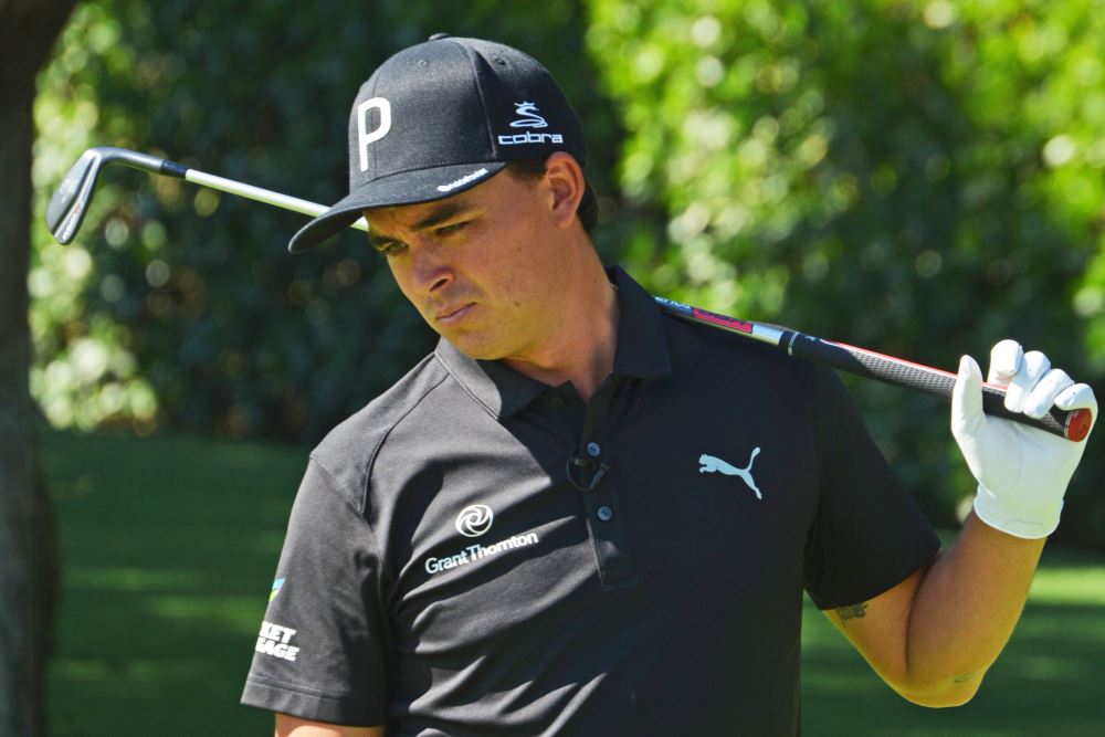 Professional PGA golfer Rickie Fowler standing with a golf club behind his head