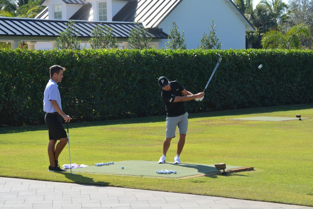 PGA tour player Rickie Fowler chipping from an artificial grass tee box