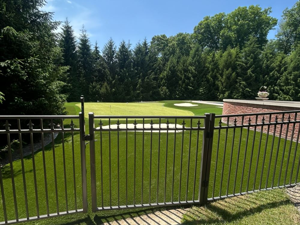 Artificial turf putting green shot from behind a fence